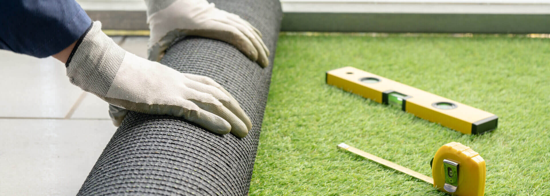 Man's Hands Spread An Artificial Turf Roll At Home